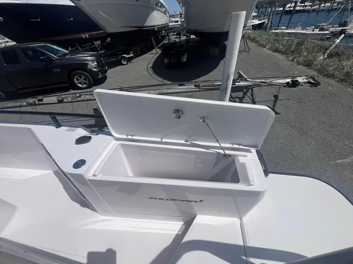  Yacht Photos Pics 2022 Axopar 28 CABIN boat with open storage compartment on deck.
