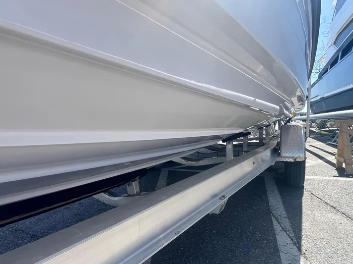  Yacht Photos Pics 2022 Axopar 28 CABIN boat on trailer, close-up view of hull and trailer.