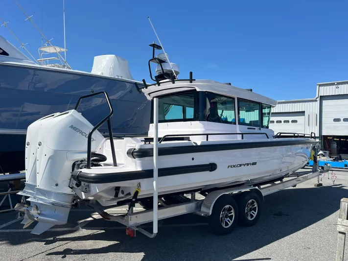  Yacht Photos Pics 2022 Axopar 28 CABIN boat on trailer, parked outdoors under clear blue sky.