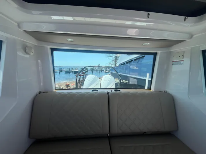  Yacht Photos Pics Interior view of 2022 Axopar 28 CABIN with rear window and seating.
