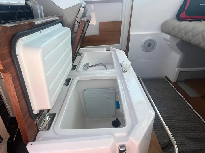  Yacht Photos Pics 2022 Axopar 28 CABIN interior with open storage compartments and seating area.