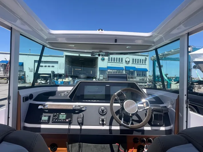  Yacht Photos Pics 2022 Axopar 28 CABIN boat interior with modern dashboard and steering wheel.