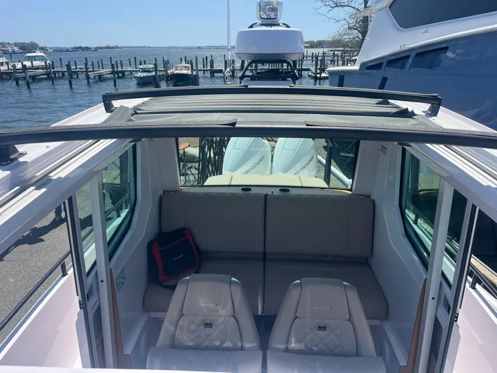  Yacht Photos Pics 2022 Axopar 28 CABIN interior with seating, open roof, and waterfront view.