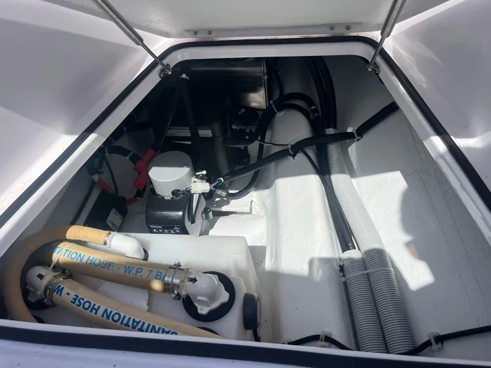  Yacht Photos Pics Engine compartment of 2022 Axopar 28 CABIN boat, showing hoses and mechanical components.