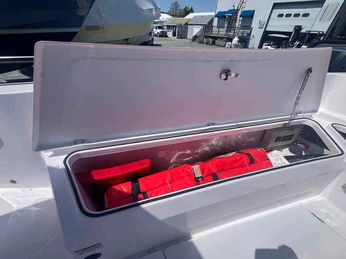  Yacht Photos Pics Open storage compartment on 2022 Axopar 28 CABIN boat with red life jackets inside.