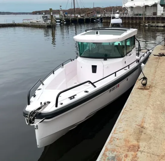  Yacht Photos Pics 2022 Axopar 28 CABIN boat docked at a marina, side view.