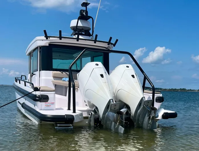  Yacht Photos Pics 2022 Axopar 28 CABIN boat with dual outboard engines in shallow water.