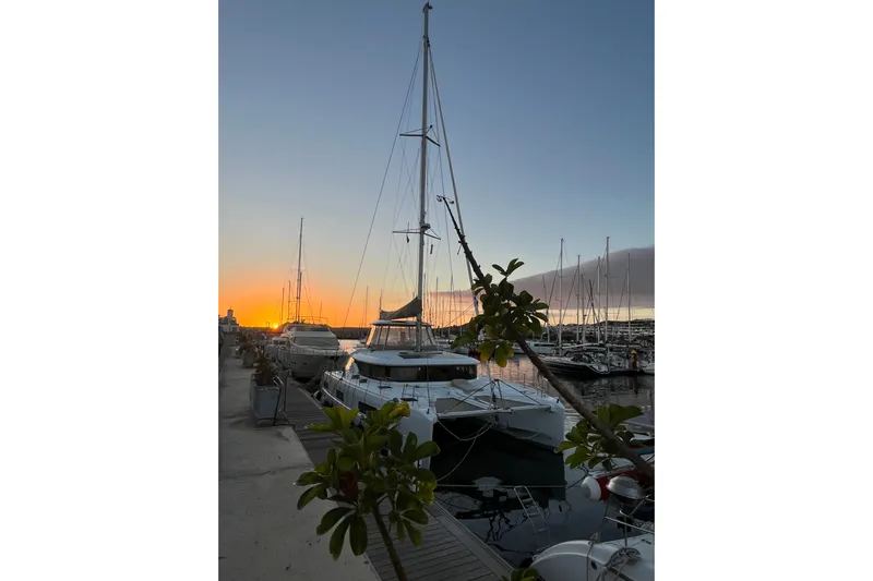  Yacht Photos Pics 2022 Lagoon 46 catamaran docked at sunset in a marina.