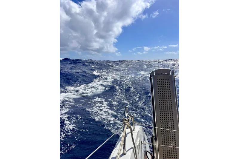  Yacht Photos Pics Sailing on a 2022 Lagoon 46 catamaran in rough ocean waters under a cloudy sky.