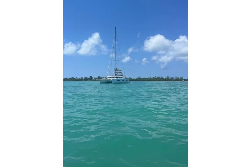  Yacht Photos Pics 2022 Lagoon 46 catamaran sailing on turquoise waters under a clear blue sky.