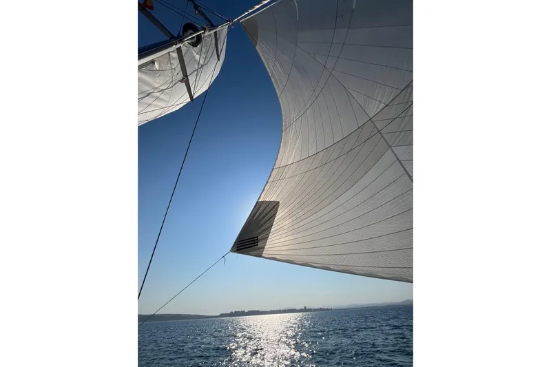 Yacht Photos Pics Sailing on a 2022 Lagoon 46 catamaran with sunlit sails over the ocean.