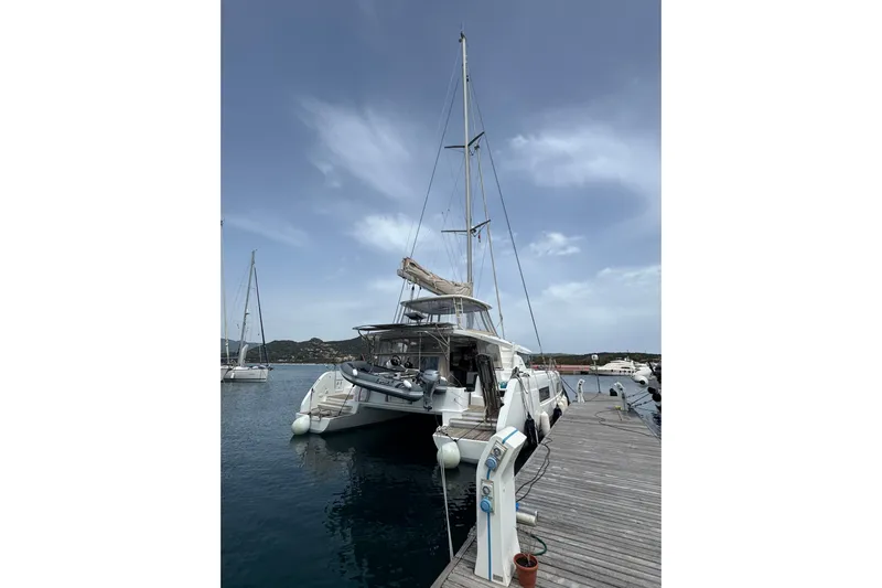  Yacht Photos Pics 2022 Lagoon 46 catamaran docked at a marina under a clear sky.