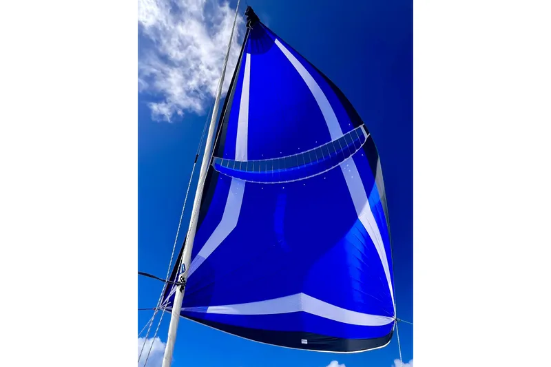  Yacht Photos Pics Blue sail of 2022 Lagoon 46 catamaran against clear sky.