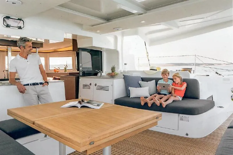  Yacht Photos Pics Family enjoying leisure time on a 2022 Lagoon 46 catamaran's deck.
