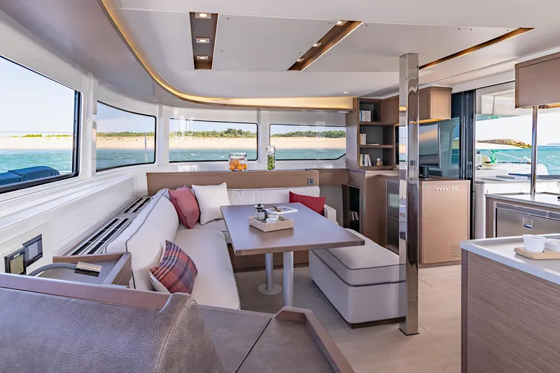  Yacht Photos Pics Luxurious interior of 2022 Lagoon 46 catamaran with modern furnishings and panoramic windows.