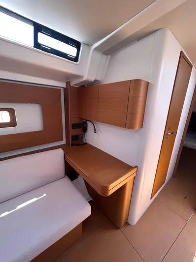  Yacht Photos Pics 2023 Beneteau First 44 interior with modern wood finish and seating area.