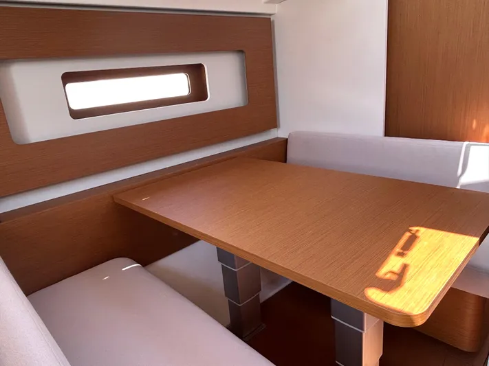  Yacht Photos Pics Interior of 2023 Beneteau First 44 yacht with wooden table and seating.