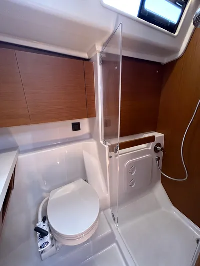  Yacht Photos Pics 2023 Beneteau First 44 yacht bathroom with modern fixtures and wood accents.