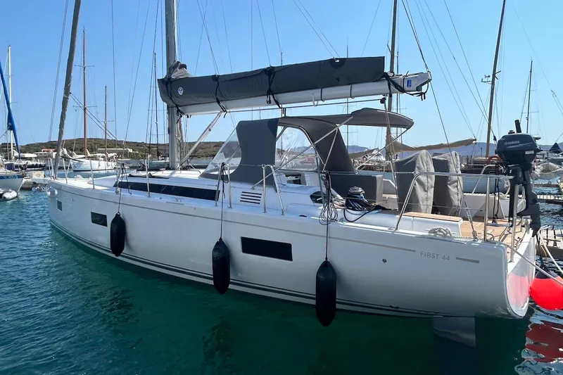  Yacht Photos Pics 2024 Beneteau First 44 sailboat docked in a marina, showcasing sleek design and modern features.