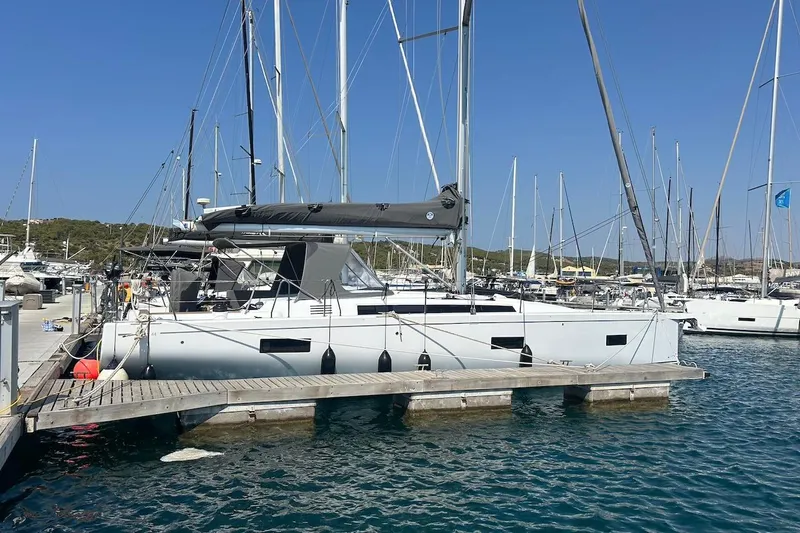  Yacht Photos Pics 2024 Beneteau First 44 sailboat docked at marina under clear blue sky.