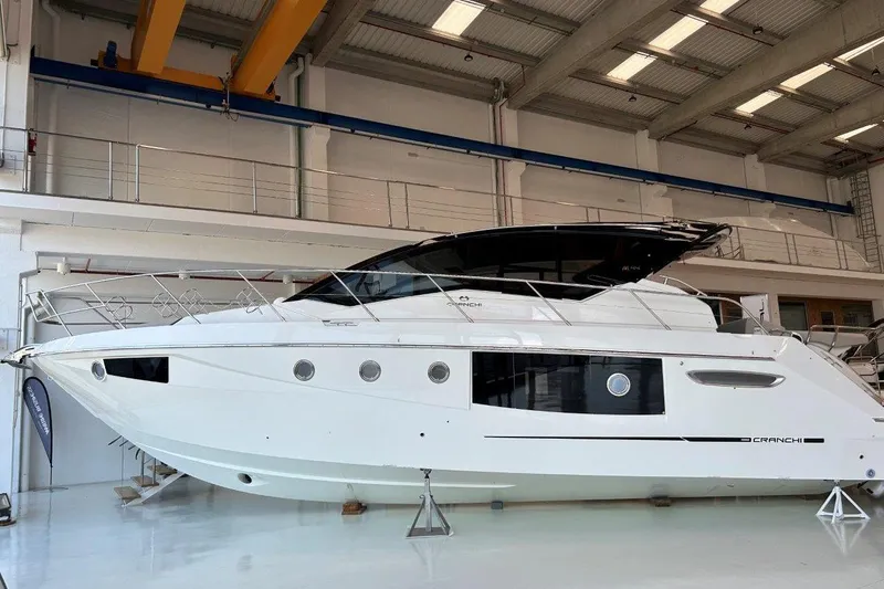 Yacht Photos Pics 2025 Cranchi M44HT yacht in showroom, sleek white design, modern luxury vessel.