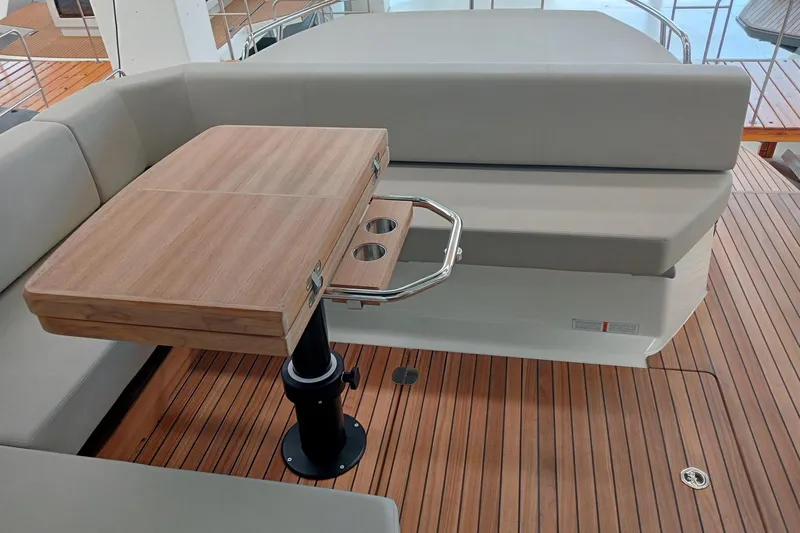  Yacht Photos Pics 2025 Cranchi M44HT yacht interior with wooden table and cushioned seating.