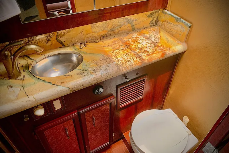 Dolce Vita Yacht Photos Pics Luxurious bathroom in 1984 Egg Harbor 48' Flybridge yacht with marble countertop and modern fixtures.