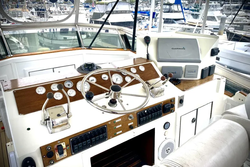 Dolce Vita Yacht Photos Pics 1984 Egg Harbor 48' Flybridge helm with Garmin navigation, gauges, and controls in marina setting.