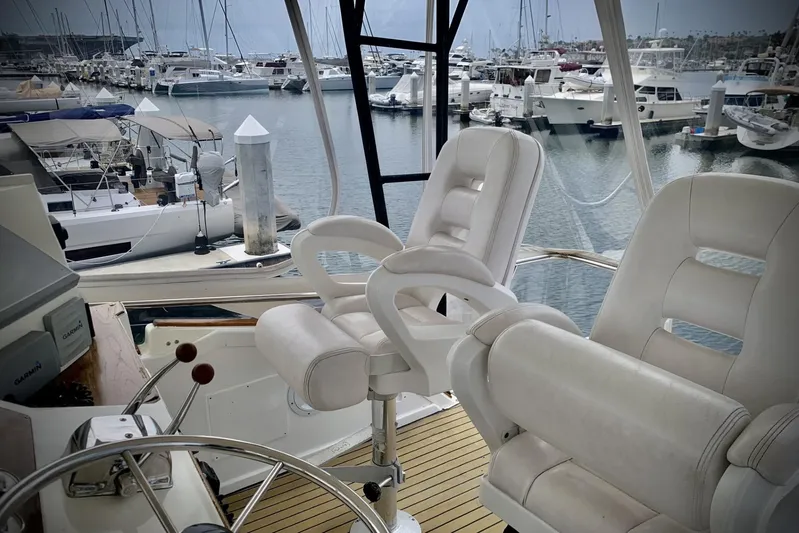 Dolce Vita Yacht Photos Pics 1984 Egg Harbor 48' Flybridge interior with white captain chairs, overlooking marina.