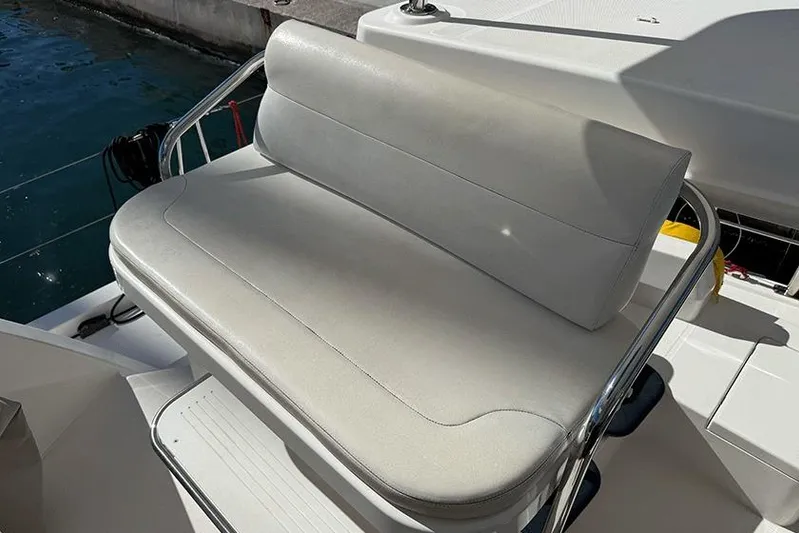  Yacht Photos Pics White cushioned seat on 2017 Leopard 48 yacht, docked by the water.
