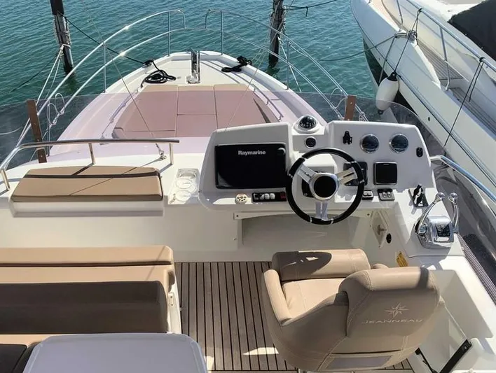 Tortuga Yacht Photos Pics 2017 Jeanneau Velasco 43F yacht helm with modern controls and seating, docked on calm water.