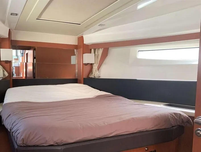 Tortuga Yacht Photos Pics Interior cabin of 2017 Jeanneau Velasco 43F yacht with a cozy bed and window.