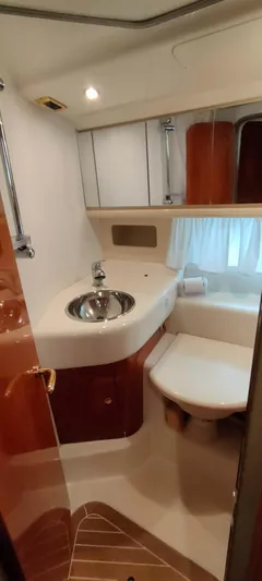  Yacht Photos Pics 2004 Cranchi Atlantique 40 yacht bathroom with sink, toilet, and wooden accents.