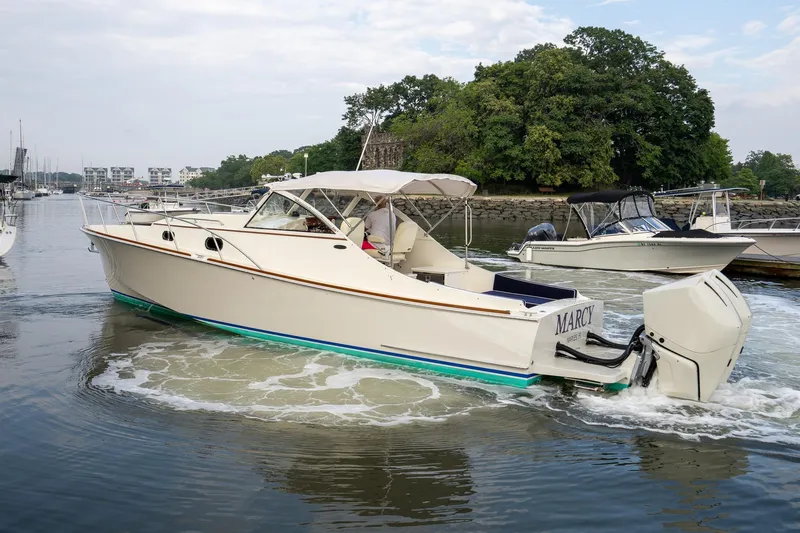 Marcy Yacht Photos Pics 2021 Brooklin Boat Yard 32 Express cruising on a calm river near lush greenery.