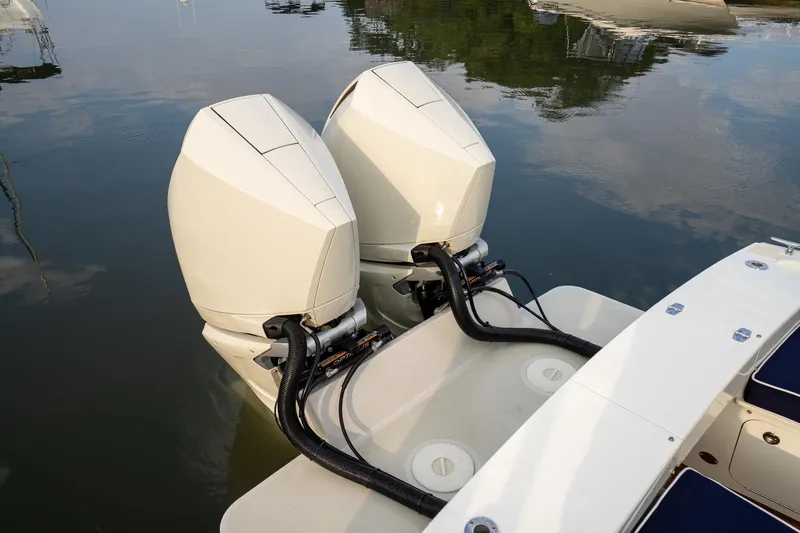Marcy Yacht Photos Pics Twin outboard engines on a 2021 Brooklin Boat Yard 32 Express, docked on calm water.