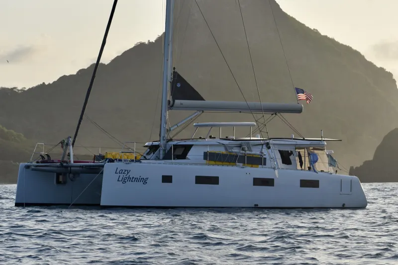 Lazy Lightning Yacht Photos Pics Catamaran "Lazy Lightning" sailing near mountainous coastline, Vision 444 model, 2021.