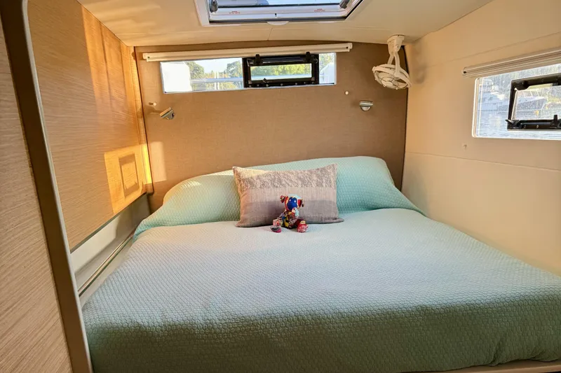Lazy Lightning Yacht Photos Pics Cozy bedroom in Vision 444, 2021 model, with plush bedding and decorative pillow.