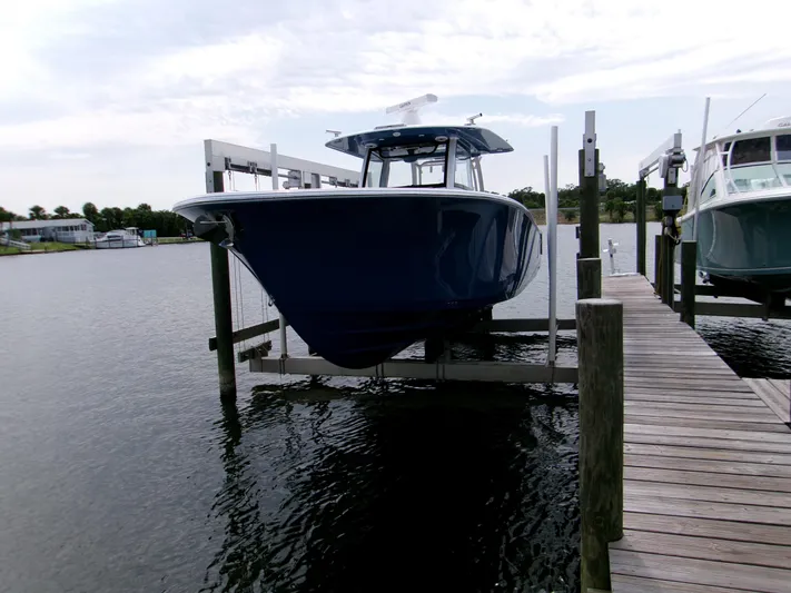  Yacht Photos Pics 2025 Sportsman Open 352 Center Console boat docked on a lift by the water.