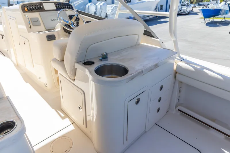  Yacht Photos Pics 2016 Grady-White Freedom 307 boat interior with helm, sink, and seating area.