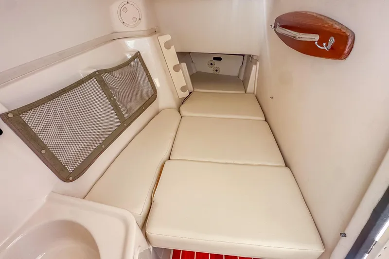  Yacht Photos Pics 2016 Grady-White Freedom 307 cabin interior with cushioned seating and storage net.