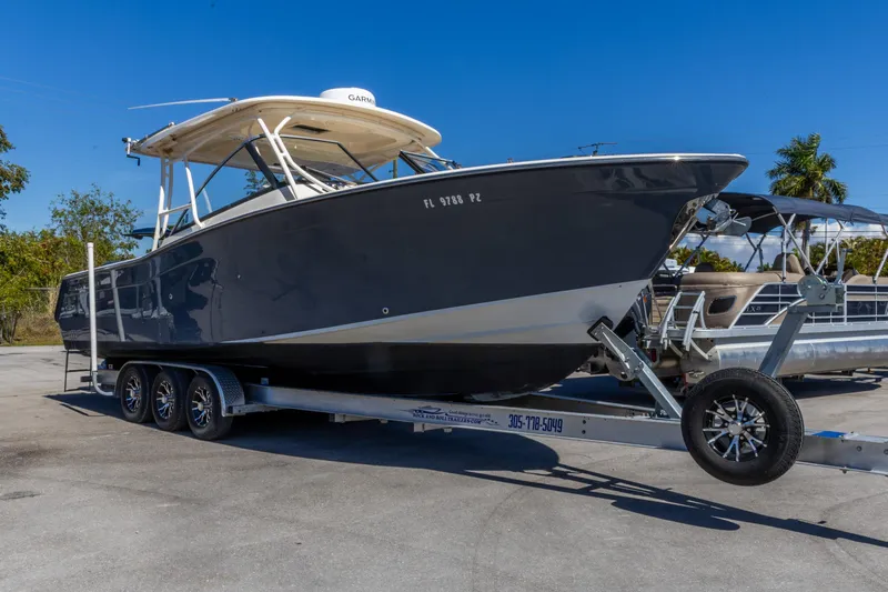  Yacht Photos Pics 2016 Grady-White Freedom 307 boat on trailer, parked outdoors under clear blue sky.