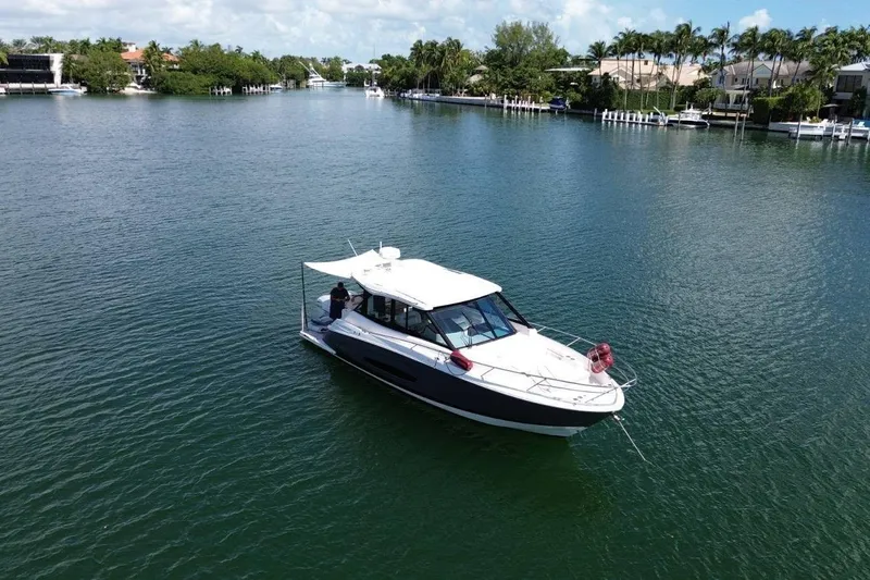  Yacht Photos Pics 2021 Regal 36 XO boat cruising on a serene waterway surrounded by lush greenery.