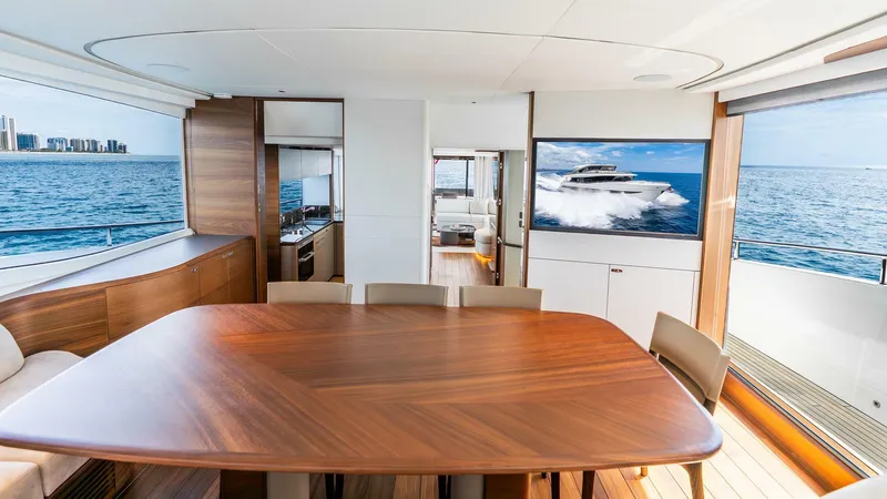 Cosa Bella Yacht Photos Pics Luxurious interior of 2024 Princess X80 yacht with ocean view and elegant wooden dining table.