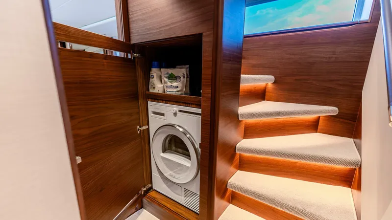 Cosa Bella Yacht Photos Pics Laundry area with washing machine on 2024 Princess X80 yacht, near carpeted stairs.