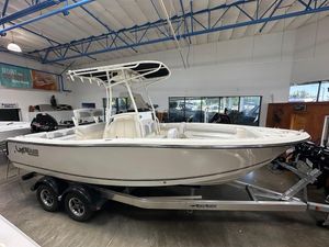 2025 Mako 214 CC boat on trailer in showroom, featuring sleek design and modern amenities.