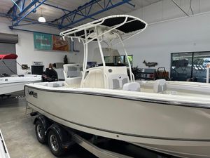 2025 Mako 214 CC boat displayed in showroom, featuring sleek design and dual-axle trailer.