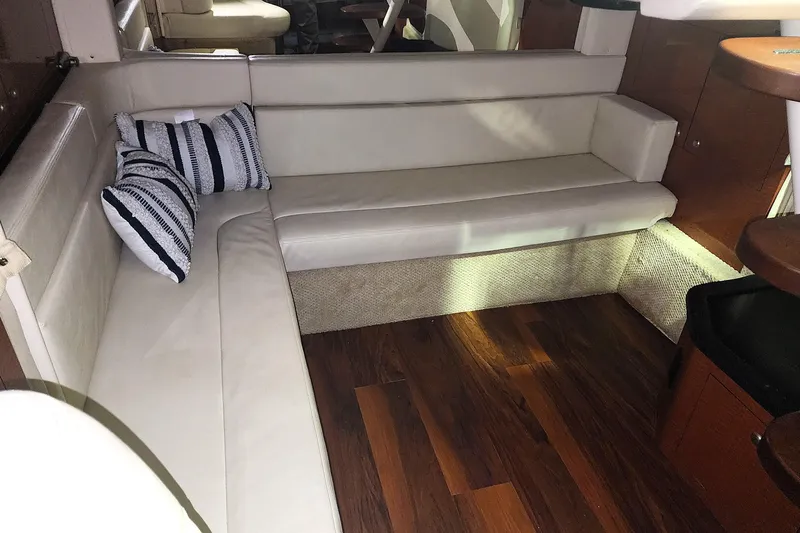 Keep The Faith Yacht Photos Pics Interior of 2005 Sea Ray 340 Sundancer with white seating and striped pillows.