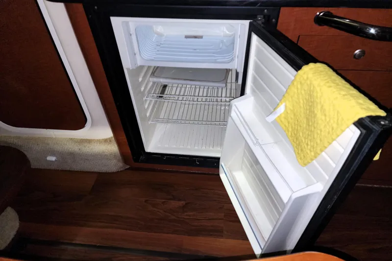 Keep The Faith Yacht Photos Pics Open mini fridge inside 2005 Sea Ray 340 Sundancer boat, with yellow cloth on door.