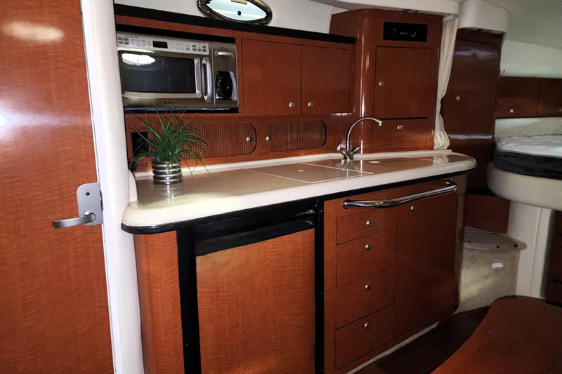 Keep The Faith Yacht Photos Pics 2005 Sea Ray 340 Sundancer interior kitchen with wood cabinets and modern appliances.