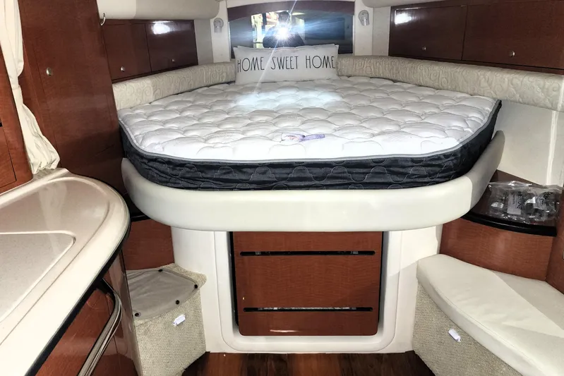 Keep The Faith Yacht Photos Pics 2005 Sea Ray 340 Sundancer cabin interior with bed, wood cabinetry, and "Home Sweet Home" pillow.